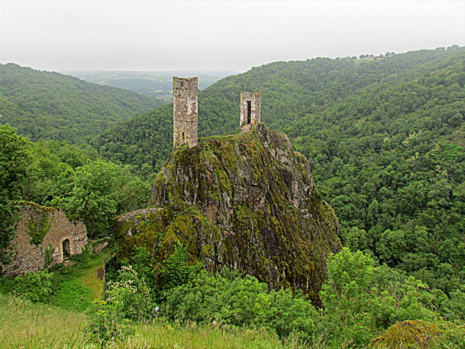 The two ruined towers of the lower castle of Peyrusse-le-Roc, perched on a rocky spur above the valley, Aveyron
