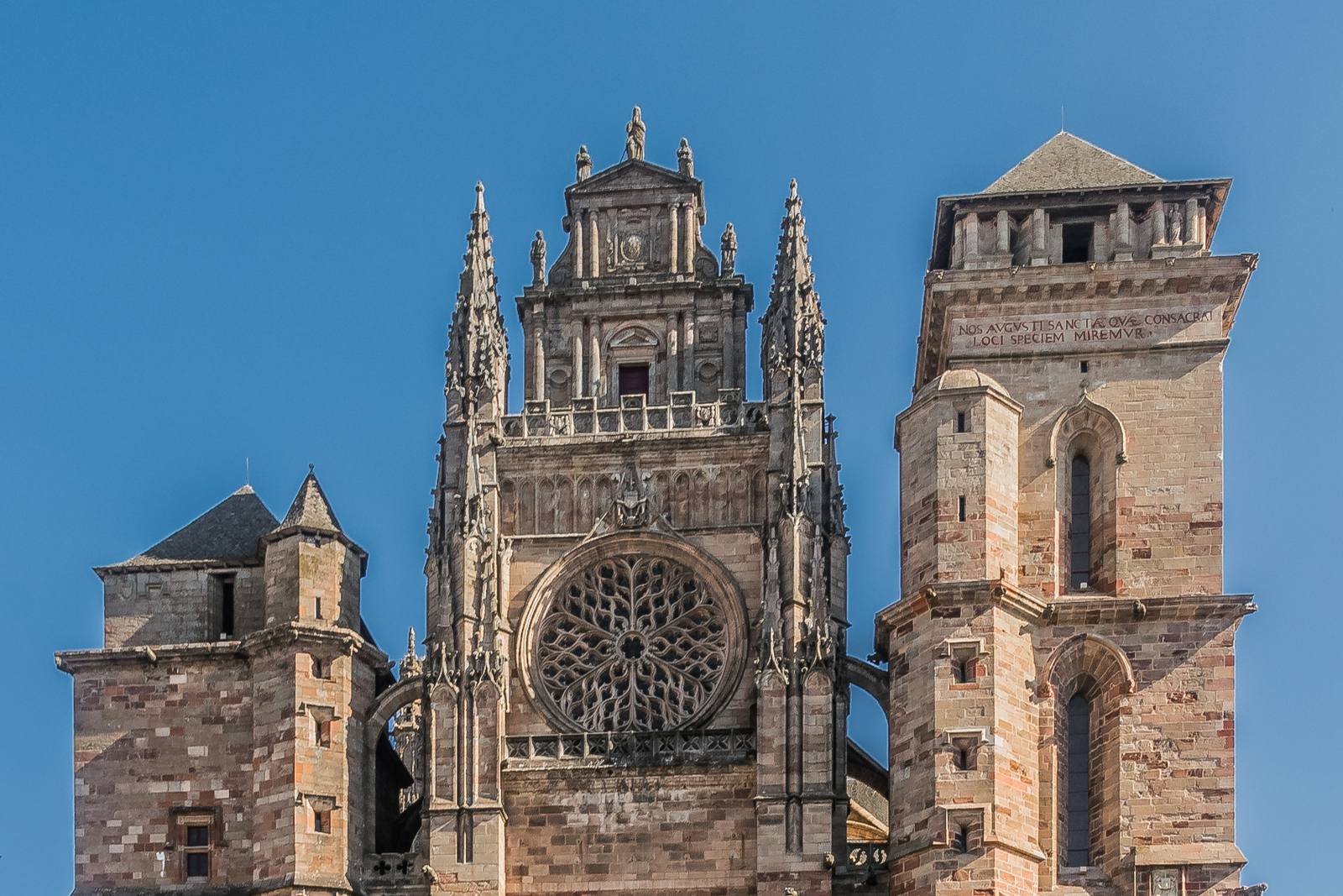 The pink sandstone façade of Notre-Dame cathedral in Rodez, with its rose window and towers
